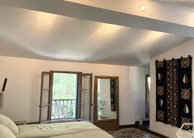 Grande chambre avec poutres apparentes, tapis berbère et douche privative, maison de location à Port-Vendres