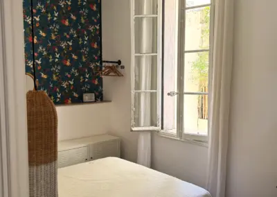Chambre avec papier peint fleuri et ventilateur de plafond, maison de location à Port-Vendres