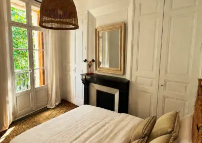 Chambre de caractère avec cheminée décorative et lustre en rotin, maison de location à Port-Vendres