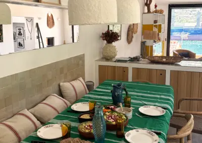 Table dressée pour le déjeuner avec vue sur le port dans la cuisine ouverte de la maison de location à Port-Vendres