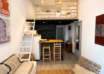 Pièce à vivre de l'appartement avec cuisine équipée et mezzanine couchage, location à Port-Vendres