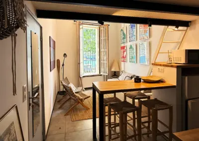 Séjour avec table haute et poutres apparentes dans le studio à louer à Port-Vendres, Côte Vermeille