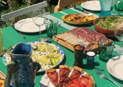 Festin estival dans le jardin de la maison de location à Port-Vendres, charcuterie, tarte aux tomates et salades