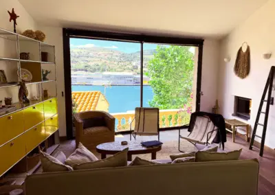 Grand salon lumineux avec cheminée et vue sur le port de Port-Vendres, location maison haut de gamme Côte Vermeille