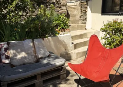 Terrasse ensoleillée avec salon de jardin et végétation méditerranéenne, maison de location à Port-Vendres